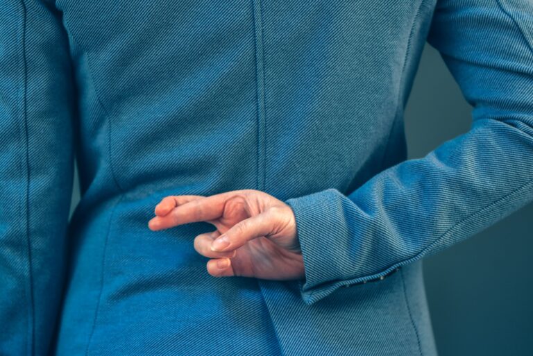 Business woman has crossed fingers behind her back