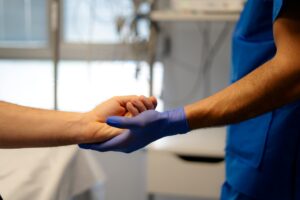 Doctor holding patient's hand providing comfort and reassurance in hospital room