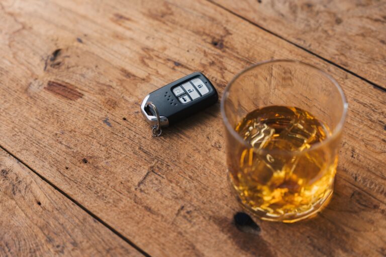 Drinking and driving concept. Car key on a wooden table.