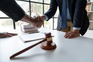 Legal and justice concept Young asian businessman shaking hands with young lawyer or legal advisor a