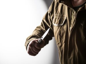 Man holding a knife in a threatening stance
