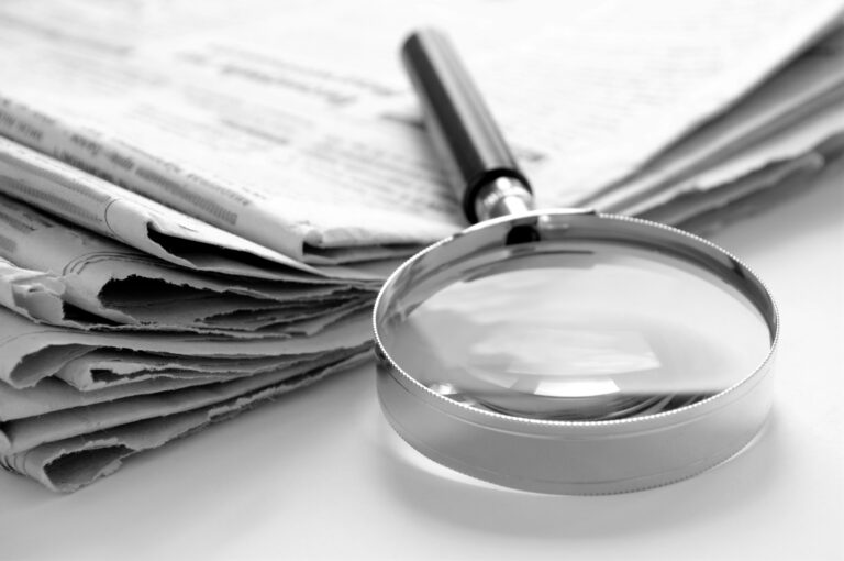newspaper and a magnifying glass