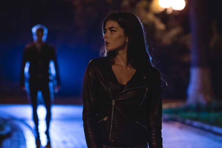 The attractive woman stand on a street on a background of the man. night time