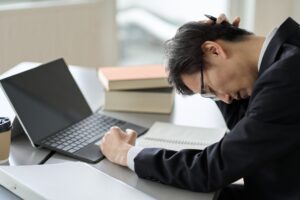 Worried asian businessman holding his head