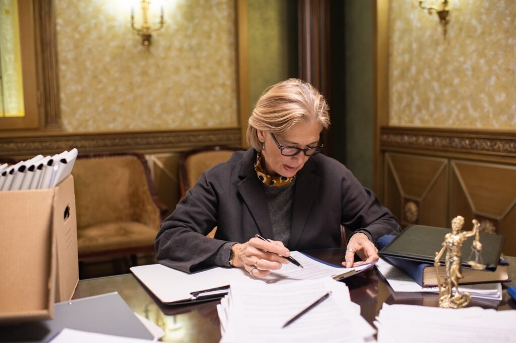 Serious female lawyer looking through papers while checking information